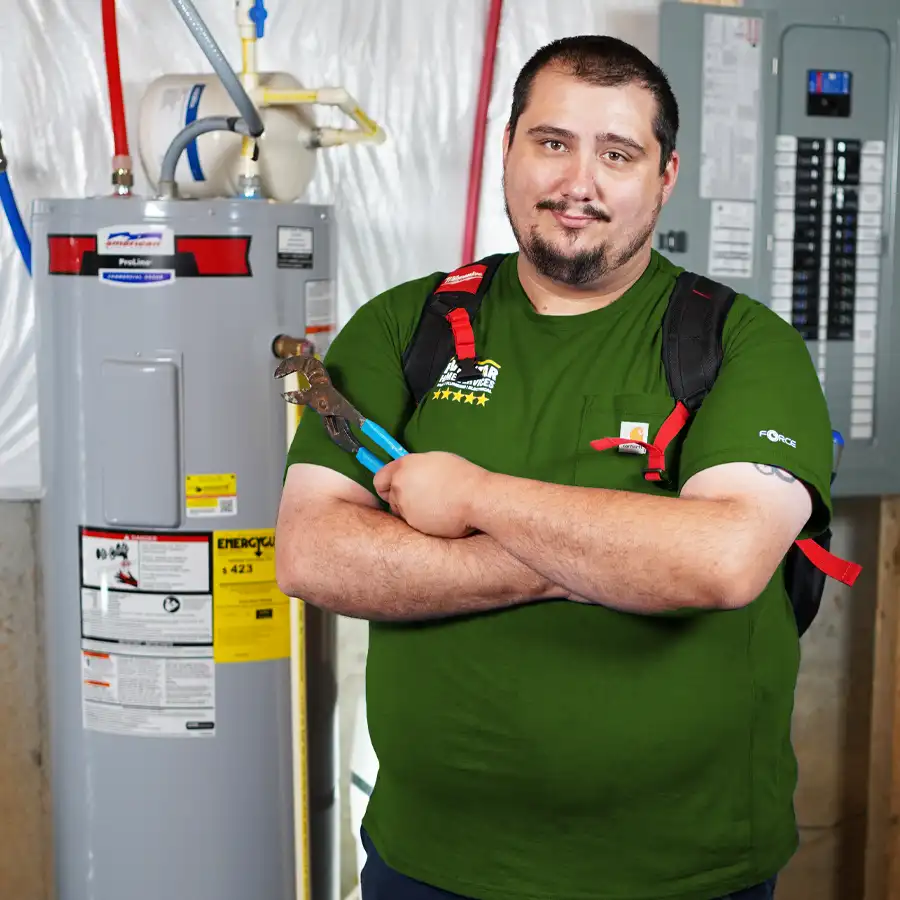 Plumber holding a wrench next to a hot water heater